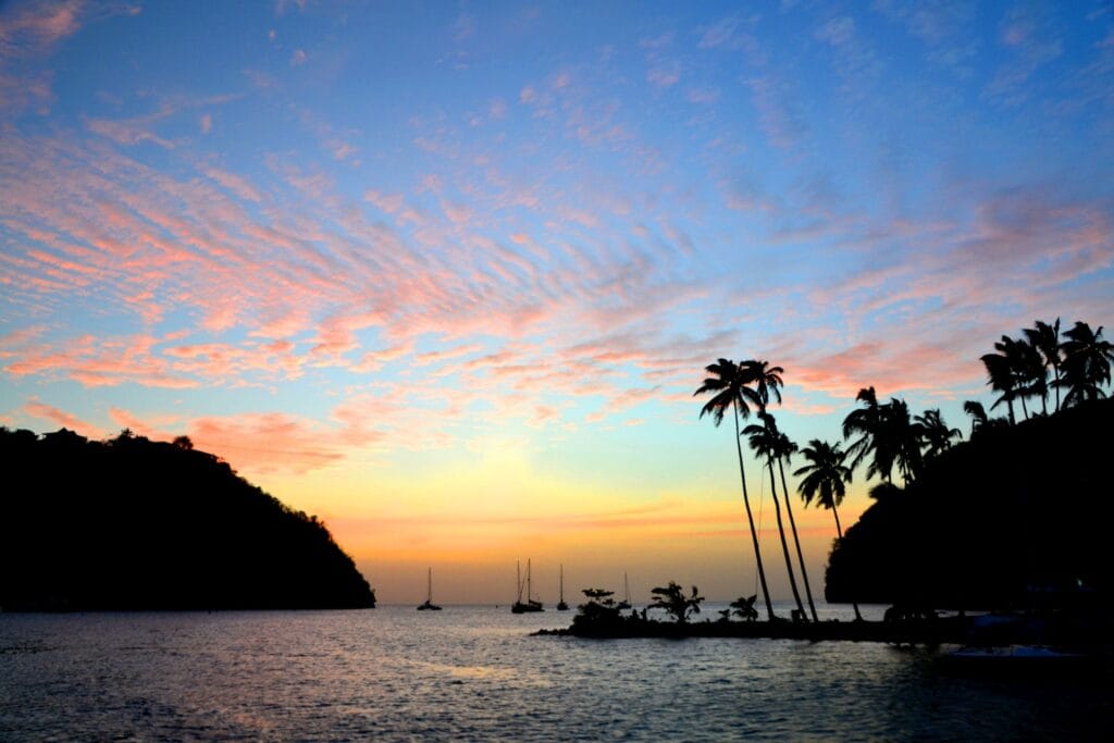 tropical caribbean pastel sunset silhouette of boats palm trees against colorful sky st lucia island